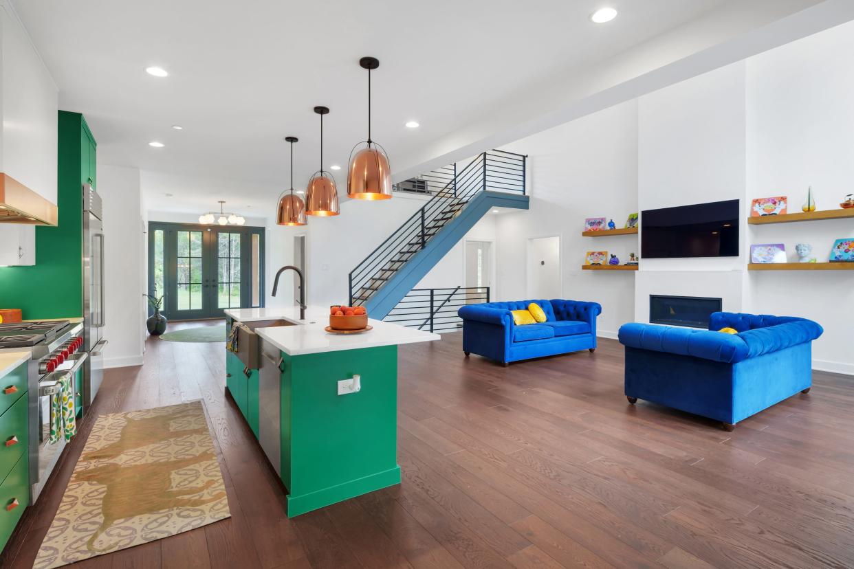 Bright blue sofas bring fun pops of color into the large, open living space in this modern farmhouse-style home built by the Eldridge Company in Louisville.