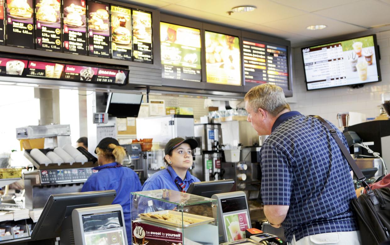 Chicago, USA - September 12, 2011: Traveler passing through Chicago O\'Hare International Airport  terminal orders fast food from McDonalds.