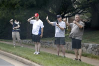 People watch the motorcade for President Donald Trump drive to Trump National Golf Club in Sterling, Va., Saturday, July 11, 2020. (AP Photo/Patrick Semansky)