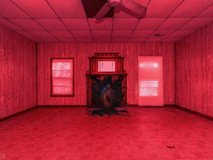 a red tinted empty living room with a monster coming out of a fireplace