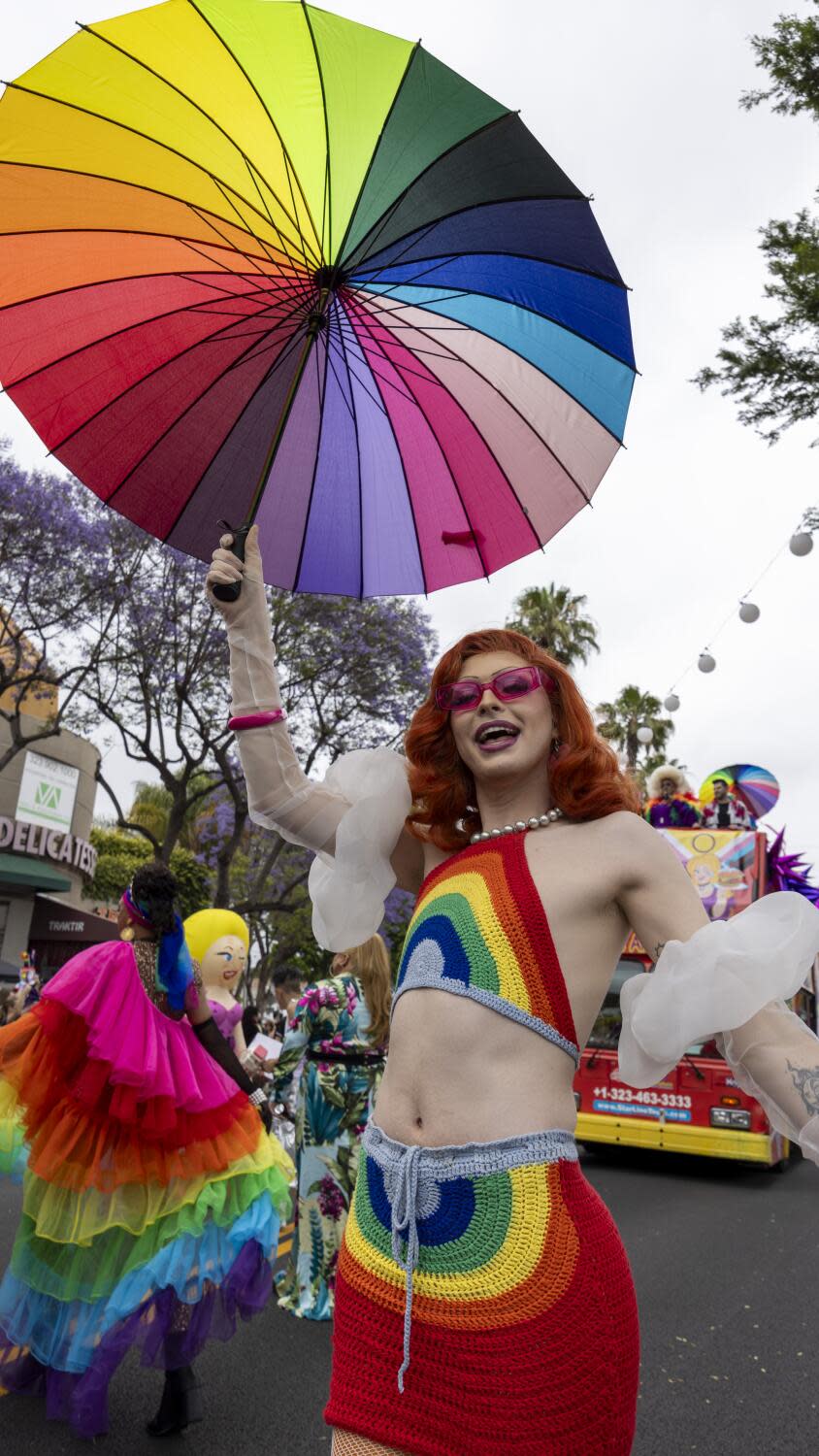 A paradegoer wears a rainbow colored crochet halter and skirt.