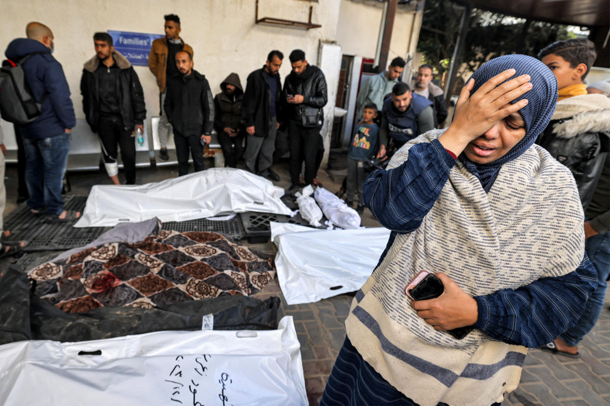 EDITORS NOTE: Graphic content / A woman mourns by the bagged bodies of Palestinians who were killed overnight during Israeli bombardment, at a hospital in Rafah in the southern Gaza Strip on December 19, 2023 amid continuing battles between Israel and the militant group Hamas. (Photo by MOHAMMED ABED / AFP) (Photo by MOHAMMED ABED/AFP via Getty Images)