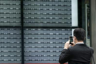 A man takes a photo of a blank electronic stock board supposedly showing Japan's Nikkei 225 index at a securities firm in Tokyo Thursday, Oct. 1, 2020. Trading on the Tokyo Stock Exchange was suspended Thursday because of a problem in the system for relaying market information. (AP Photo/Eugene Hoshiko)