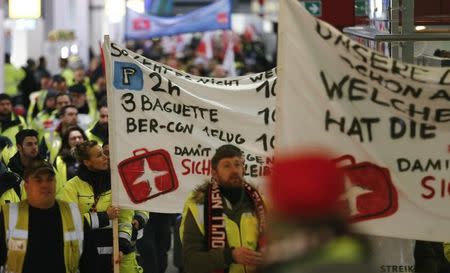 FILE PHOTO: Members of Germany's mighty Verdi union march through the main hall of Berlin Tegel airport during a warning strike by ground services, security checks and check-in staff in Berlin, Germany, February 8, 2017. REUTERS/Hannibal Hanschke