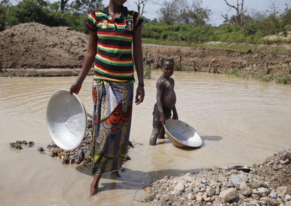 A mother and her child pan for gold and diamonds near the town of Gaga