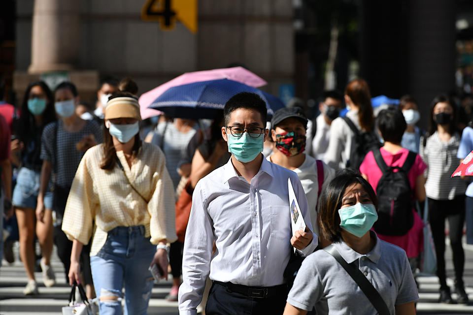 Taipei, Taiwan-06 30 2020:Group of people wearing protective face masks crossing a street in Taipei city, Taiwan during the global coronavirus epidemic.