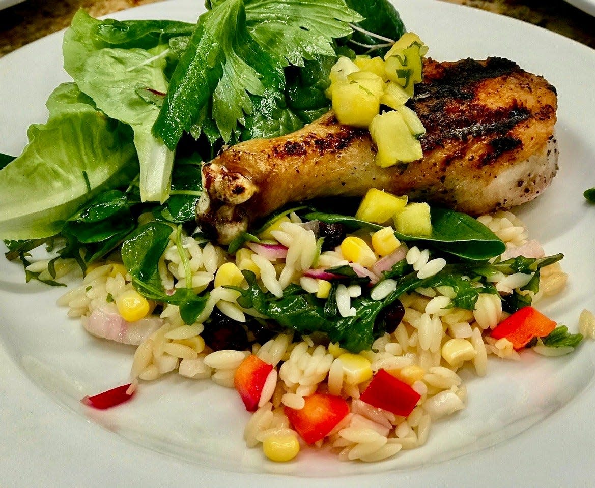 Grilled chicken with pineapple mint salsa, fresh greens and orzo pasta salad