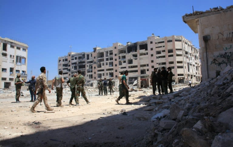 Syrian army soldiers patrol the area around the entrance of Bani Zeid after seizing the district of Leramun, on the northwest outskirts of Aleppo, from rebels on July 28, 2016