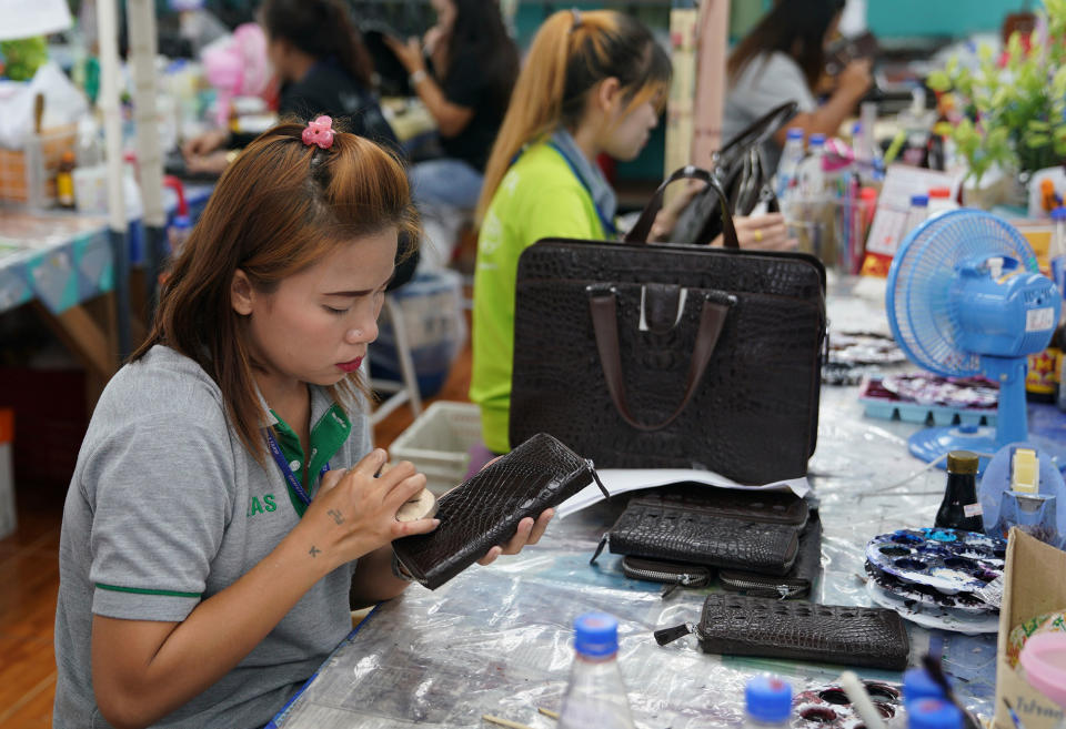 A worker polishes a wallet