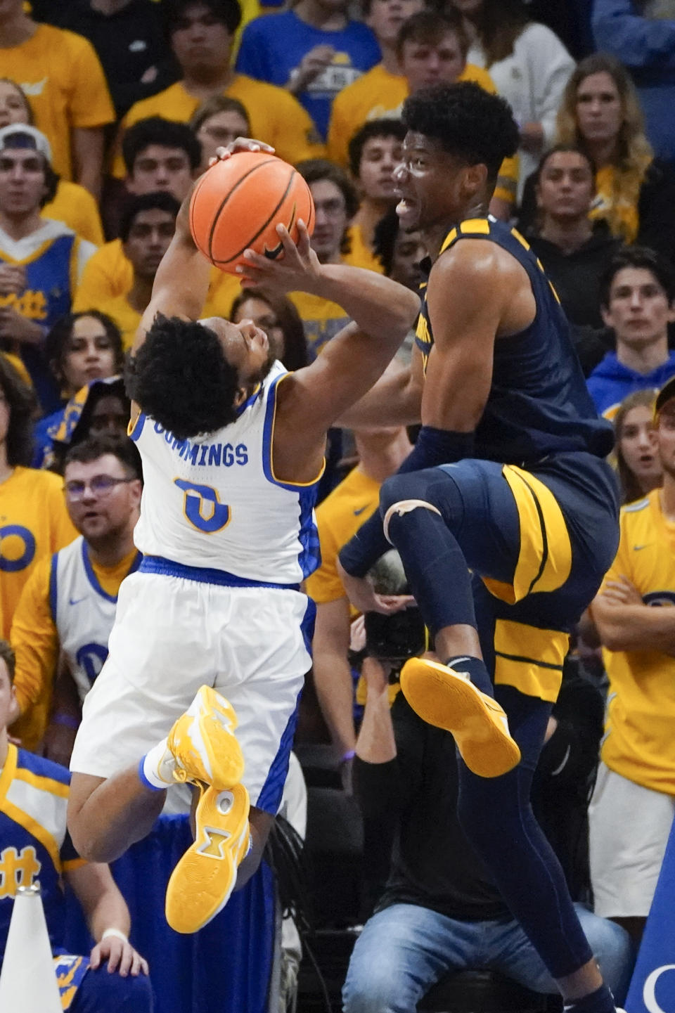 Pittsburgh's Nelly Cummings (0) shoots as West Virginia's Mohamed Wague, right, defends during the first half of an NCAA college basketball game, Friday, Nov. 11, 2022, in Pittsburgh. (AP Photo/Keith Srakocic)