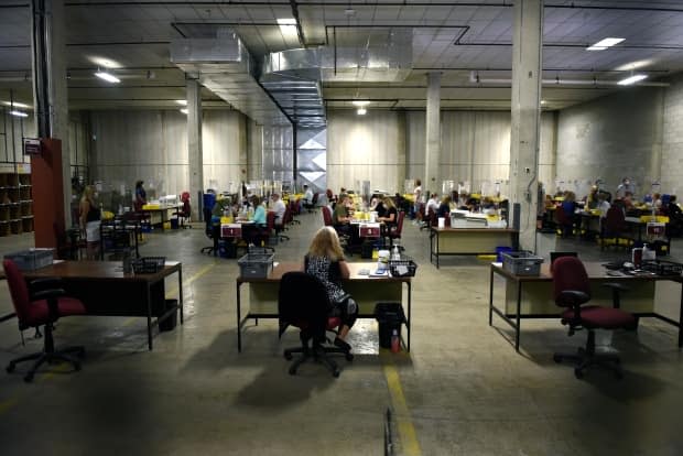 Elections Canada officers count special ballots from national, international, Canadian Forces and incarcerated electors in Ottawa on election night of the 44th Canadian general election. (Justin Tang/The Canadian Press - image credit)