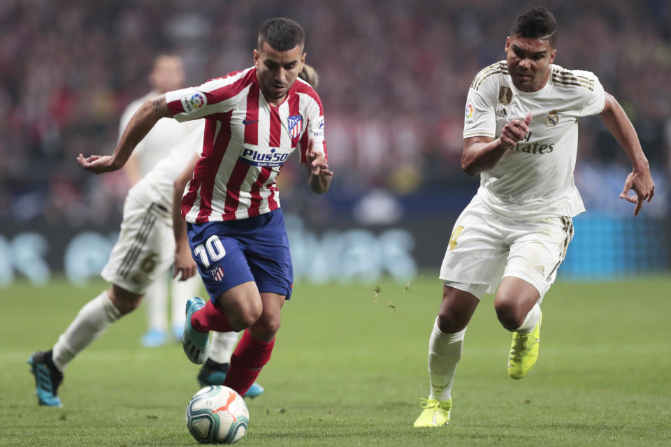 Atletico Madrid's Angel Correa, left, and Real Madrid's Casemiro vie for the ball during the Spanish La Liga soccer match between Atletico Madrid and Real Madrid at the Wanda Metropolitano stadium in Madrid, Saturday, Sept. 28, 2019. (AP Photo/Bernat Armangue)