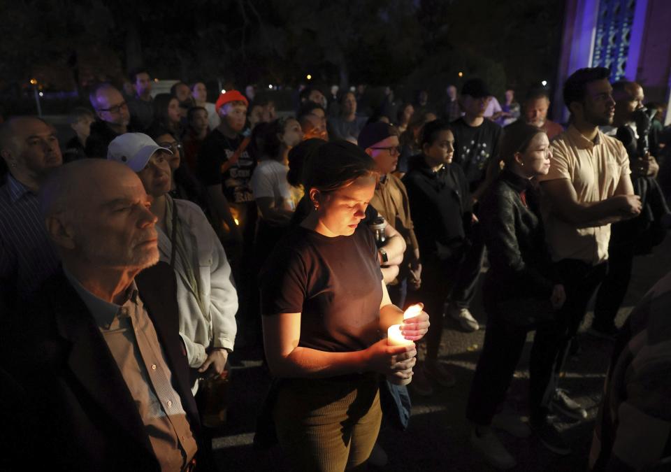 Marie Crane (centro) sostiene una vela durante una vigilia en el parque Tower Grove por las víctimas de un tiroteo en la Secundaria Central de Artes Visuales y Escénicas en San Luis, Missouri, la noche del lunes 24 de octubre de 2022. (David Carson/St. Louis Post-Dispatch vía AP)