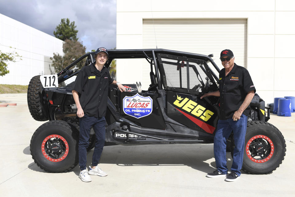 This March 9, 2019, photo provided by Auto Imagery shows former drag racer Don Prudhomme, left, and Jagger Jones at the Snake Racing Performance Shop in Vista, Calif. Prudhomme swore he would never enter the Mexican 1000 again after struggling to get through the difficult off-road race in Baja California. A year later, The Snake is tackling it again, this time with 16-year-old Jagger Jones at his side.(Richard Shute/Auto Imagery via AP)