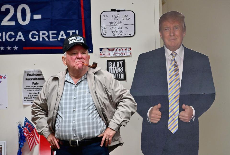 President Donald Trump supporter Tom Kenney wearing a "Cops for Trump" hat stands next to a cardboard cutout of the president as he watches the first presidential debate between Trump and Democratic presidential nominee and former Vice President Joe Biden on Tuesday in Old Forge, near Scranton, Pennsylvania.