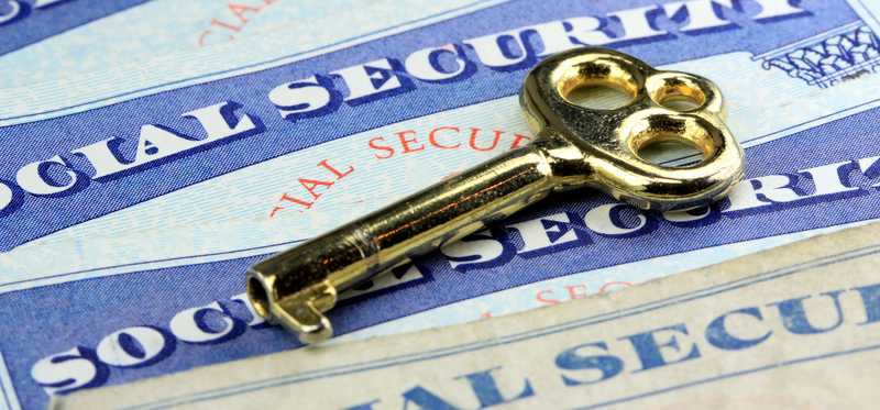 A gold key atop a social security card.