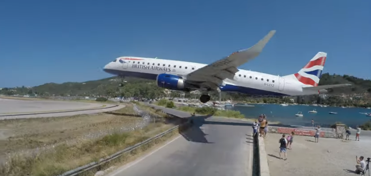 Dramatic video shows the moment a plane whisks mere metres above the heads of tourists in Greece.The British Airways Embraer E190 aircraft was filmed at Skiathos airport in Greece as it was approaching the runway to land.Skiathos airport is dubbed by aviation enthusiasts “European St Maarten” due to its low landing.On the Caribbean island of St Maarten, hundreds of people gather to watch jumbo jets land just beyond a popular tourist beach.The airport on the Greek island is a popular tourist attraction, with planespotters lining up on the road behind the runway.People are warned not to get too close to the runway, with a sign saying: “Danger. Please keep away from aircraft blast.”The footage of the British Airways landing shows people being pushed off a wall by the gust from the aircraft blast.The biggest aircraft that is permitted to land at Skiathos is a Boeing 757, a narrow-body jet, according to aviation enthusiast YouTube account Cargospotter.