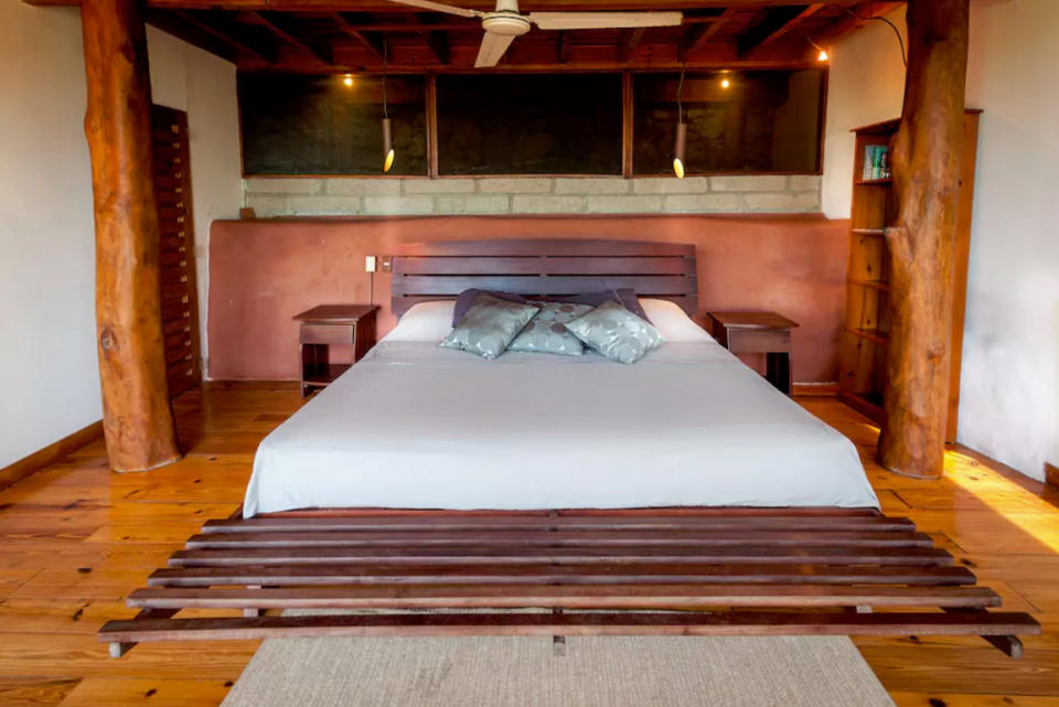 <p>The luxurious modern bedroom boasts wood floors and beams, as well as fantastic panoramic view. (Airbnb) </p>