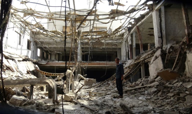 A man inspects the ruins of a factory hit by fierce fighting for the Yemeni port city of Hodeida that a UN-brokered truce which went into effect on Tuesday is intended to halt