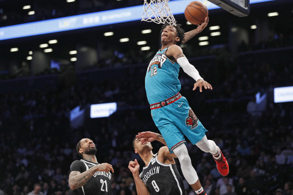 FILE - In this March 4, 2020, file photo, Memphis Grizzlies guard Ja Morant (12) attempts a dunk as Brooklyn Nets forward Wilson Chandler (21) and guard Timothe Luwawu-Cabarrot (9) watch during the second half of an NBA basketball game in New York. Morant was announced Wednesday, Sept. 2, 2020, as the winner of the Rookie of the Year award for 2019-20, the first Grizzlies player to win the award since Pau Gasol in 2001-02. (AP Photo/Kathy Willens, File)