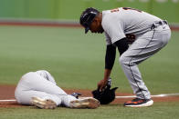 Detroit Tigers' Derek Hill lays on the field as first base coach Kimera Bartee leans over during the fifth inning of a baseball game against the Tampa Bay Rays Saturday, Sept. 18, 2021, in St. Petersburg, Fla. (AP Photo/Scott Audette)