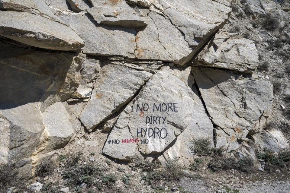 A message saying "No More Dirty Hydro" is painted on a rock by the roadside near Akpa village in Kinnaur district of the Himalayan state of Himachal Pradesh, India, Monday, March 13, 2023. In past years resentment against the hydroelectric dams has grown, mirroring concerns across the environmentally sensitive Himalayas about building dams with inadequate assessments. (AP Photo/Ashwini Bhatia)