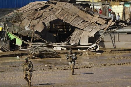 Soldiers patrol a flooded river area at Chanaral town, March 27, 2015. REUTERS/Ivan Alvarado