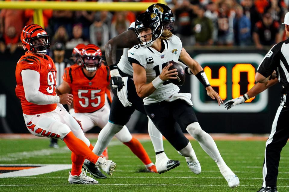 Jacksonville Jaguars quarterback Trevor Lawrence (16) spins out of pressure in the fourth quarter during a Week 4 NFL football game against the Cincinnati Bengals, Thursday, Sept. 30, 2021, at Paul Brown Stadium in Cincinnati.