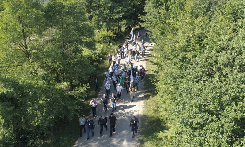 People walk through a forest near the village of Snagovo