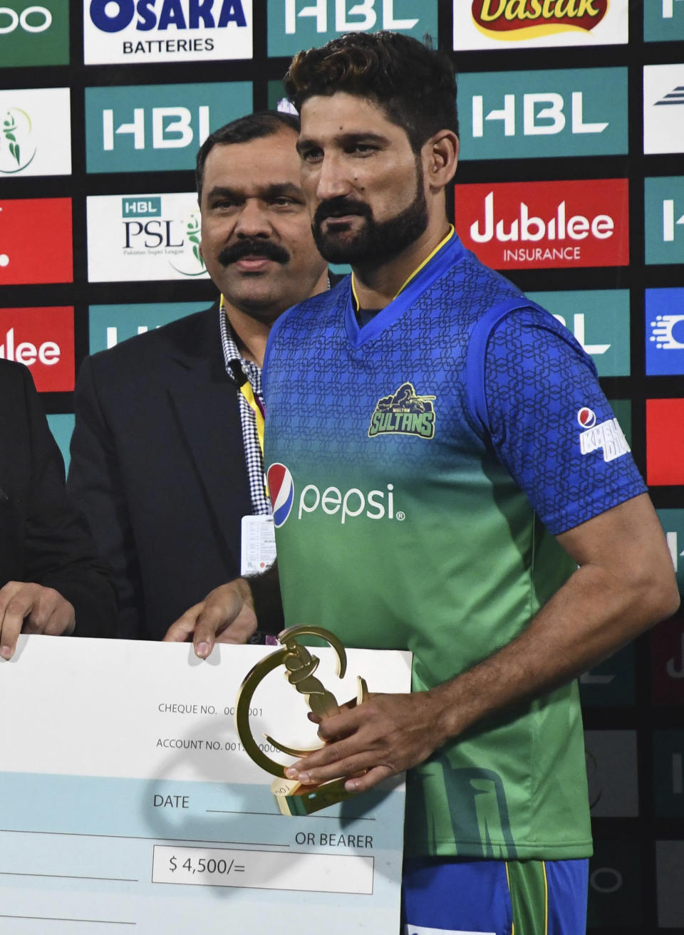 Sohail Tanvir of Multan Sultans receives the cheque and trophy after being declared man of the match in the Pakistan Super League match against Peshawar Zalmi at Multan Cricket Stadium, Wednesday, Feb. 26, 2020. Multan beat Peshawar by six wickets. (AP Photo/Asim Tanveer)