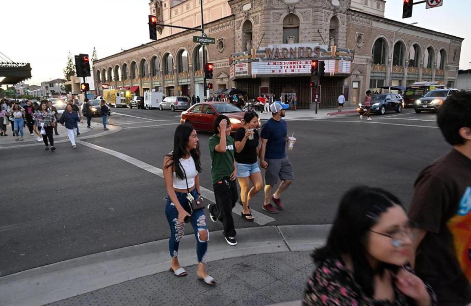 Pedestrians cross in front of the Warnors Center for the Performing Arts, background, as thousands descend on Fulton Street during ArtHop Thursday, Aug. 3, 2023.