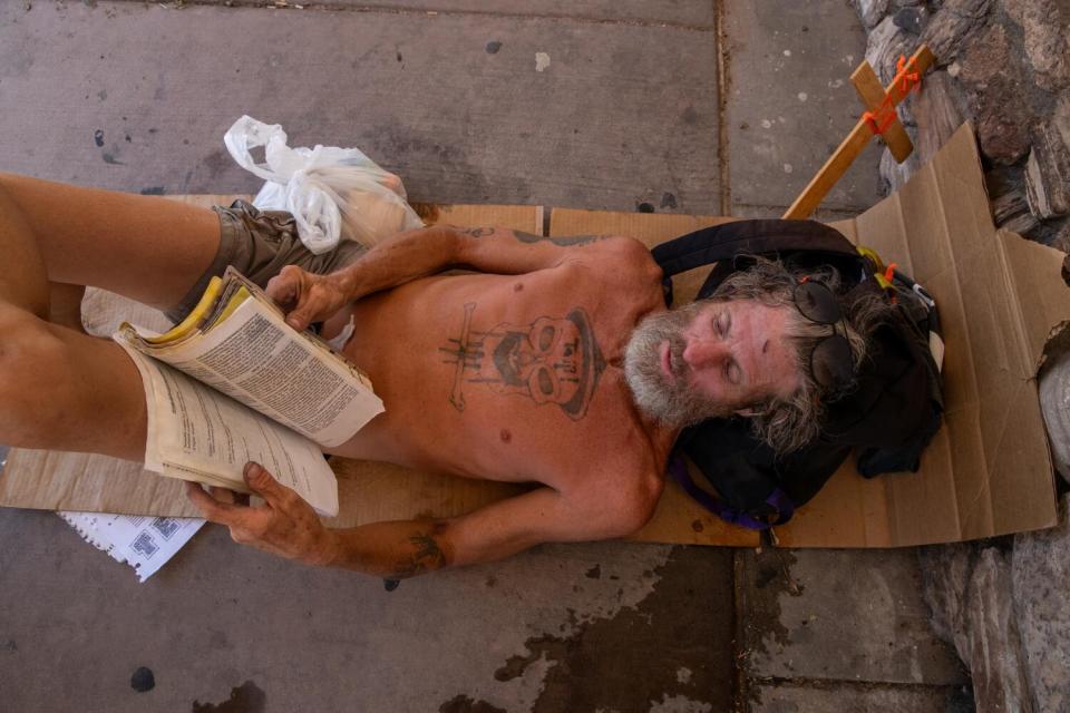 Dray Taije rests in the shade of a vacant business in Blythe.