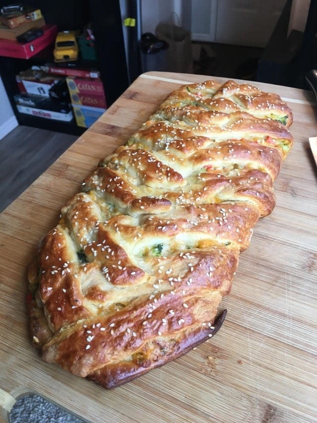 A braided bread with chicken and broccoli.