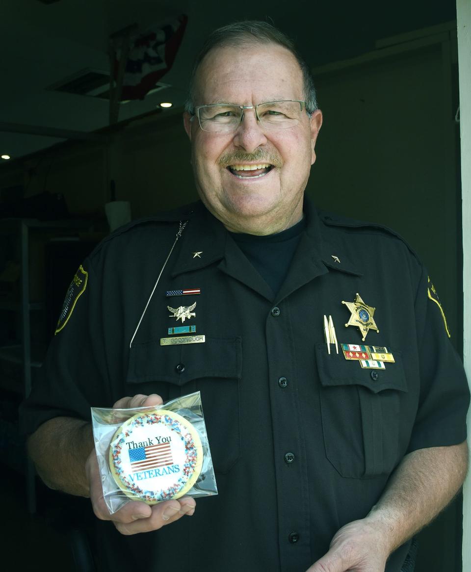 Monroe County Sheriff Troy Goodnough was proud as he displayed one of the cookies that were given to the veterans at the Veterans Day program Monday at the fair.