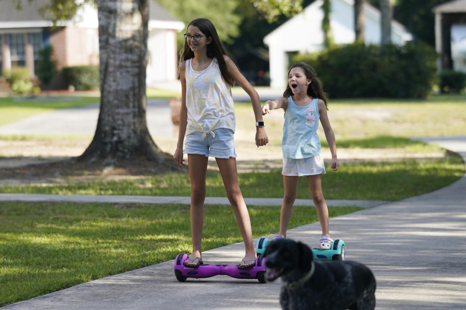 Cecilia Shaffette plays in the driveway with her sister Lydia, right, at their home in Carriere, Miss., Wednesday, June 16, 2021. (AP Photo/Gerald Herbert)