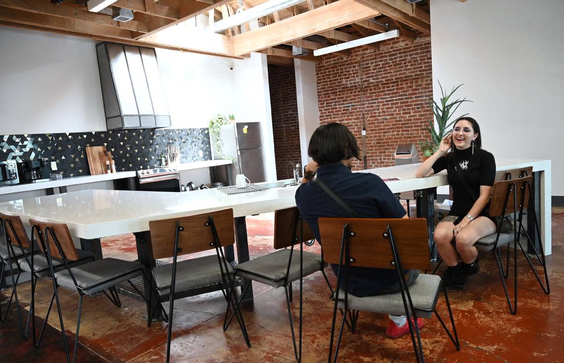 Paper Crane Gallery’s Daniel De Meza, left, and Angel Lesnikowski, right, relax in the communal kitchen area at Sun Stereo Warehouse on Fulton Street Thursday, Aug. 18, 2022 in downtown Fresno.