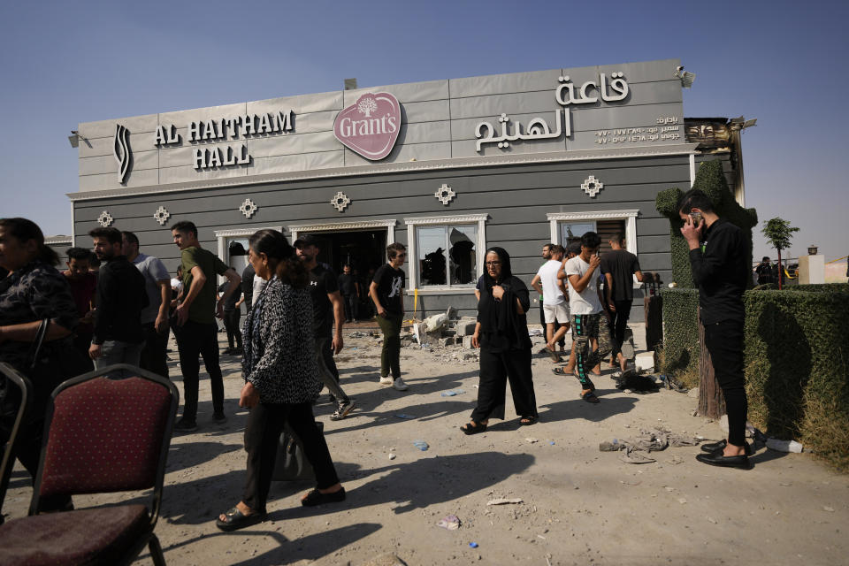 People react at the site of a fatal fire in the district of Hamdaniya, Nineveh province, Iraq, Thursday, Sept. 28, 2023. A fire that raced through a hall hosting a Christian wedding in northern Iraq killed multiple people, authorities said .(AP Photo/Hadi Mizban)