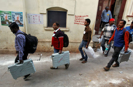 Polling officials carry Electronic Voting Machines (EVM) after the end of the last phase of polling during Uttar Pradesh state assembly election, in Varanasi, India March 8, 2017. REUTERS/Jitendra Prakash