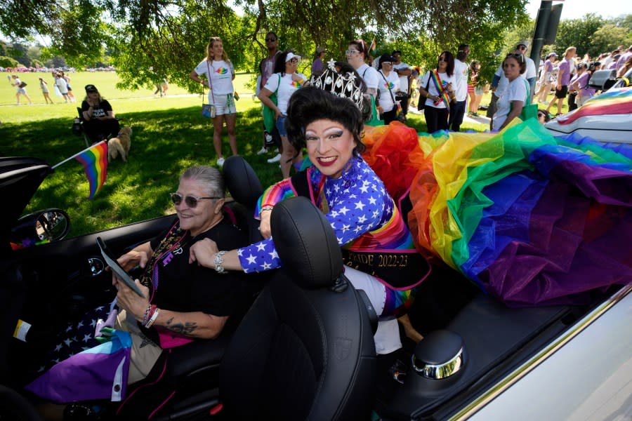 Michael Sanchez rides in the back of a convertible to take part in the Pride parade through the streets of downtown Sunday, June 25, 2023, in Denver. (AP Photo/David Zalubowski)