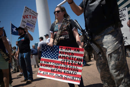 Gun advocates carry firearms and hold signs during an open carry firearm rally on the sidelines of the annual National Rifle Association (NRA) meeting in Dallas, Texas, U.S., May 5, 2018. REUTERS/Adrees Latif