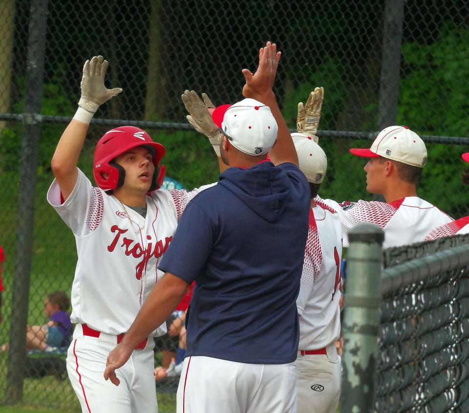 Bridgewater-Raynham's Evan Samsel gets high-fives from his coaches and teammates for hitting a sacrifice fly.