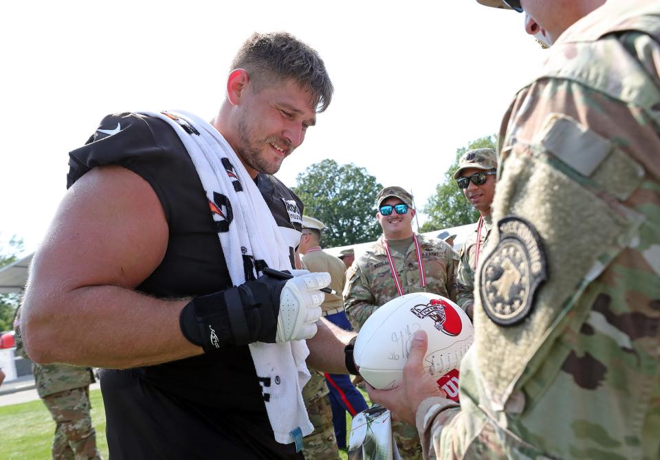 Cleveland Browns guard Wyatt Teller signs autographs for servicemen after the NFL football team's football training camp in Berea on Wednesday.