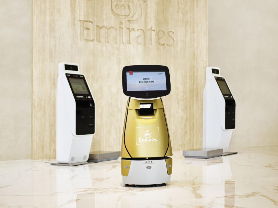 Emirates' check-in robot and two of its self-service kiosks. The robot is called Sara.