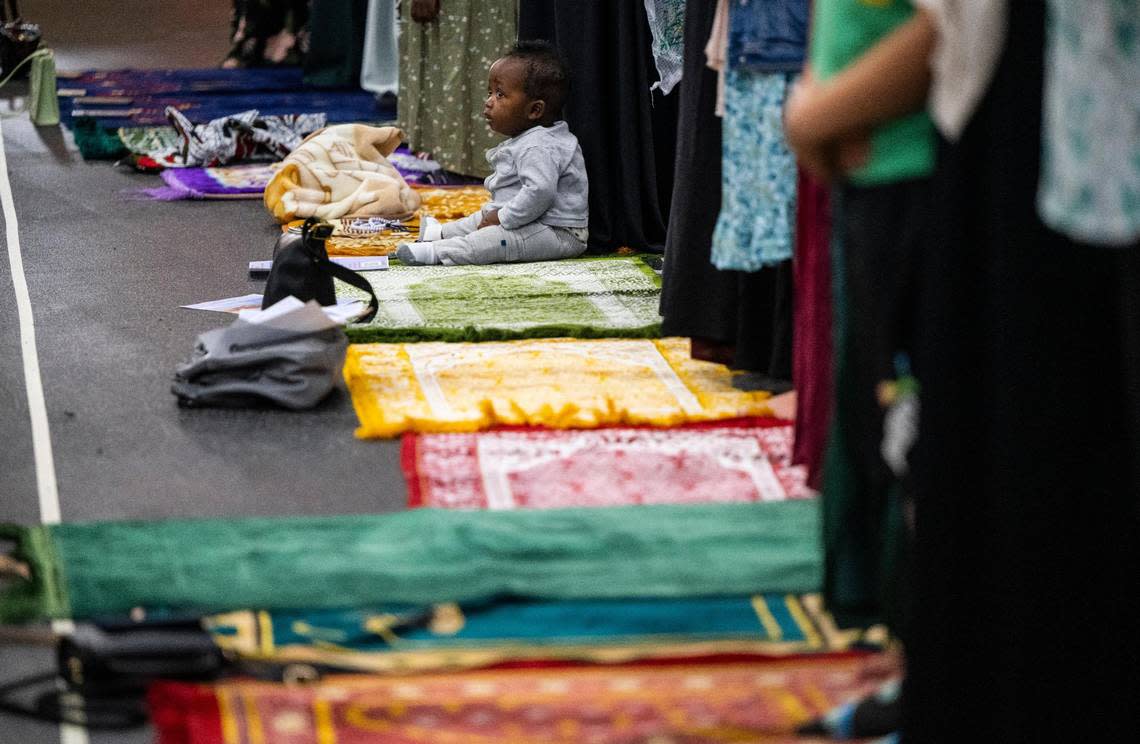 A child sits on a prayer rug during a prayer led by Imam Abdulhakim Mohammed for a celebration of the Islamic holiday, Eid al-Adha, at what will soon be the new Islamic Center on Montana Avenue in Tacoma, on Saturday, July 9, 2022.