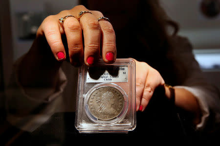 A Sotheby's employee adjusts the Sultan of Muscat-Brands-Childs 1804 Silver Dollar which is displayed as part of the D. Brent Pogue collection to be sold on Tuesday at Sotheby's in New York, U.S., May 24, 2016. REUTERS/Lucas Jackson