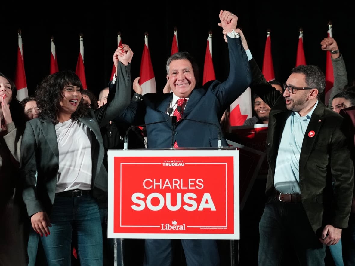 Federal cabinet ministers Iqra Khalid, left, and Omar Alghabra, right, flank Liberal candidate Charles Sousa at the byelection night headquarters for the riding of Mississauga-Lakeshore in Mississauga, Ont., on Monday.  (Nathan Denette/The Canadian Press - image credit)