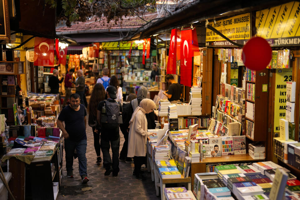 A young woman, right, looks at university text books at a book shop in Istanbul, Turkey, Friday, Nov. 3, 2023. Turkey is marking its centennial but a brain drain is casting a shadow on the occasion. Government statistics indicate that a growing number of the young and educated are looking to move abroad in hopes of a better life, mainly in Europe. (AP Photo/Francisco Seco)