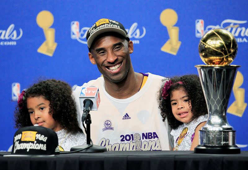 FILE PHOTO: Lakers' Bryant smiles with daughters Gianna and Natalia with the Bill Russell MVP Trophy after his team defeated the Celtics in Game 7 to win the 2010 NBA Finals basketball series in Los Angeles