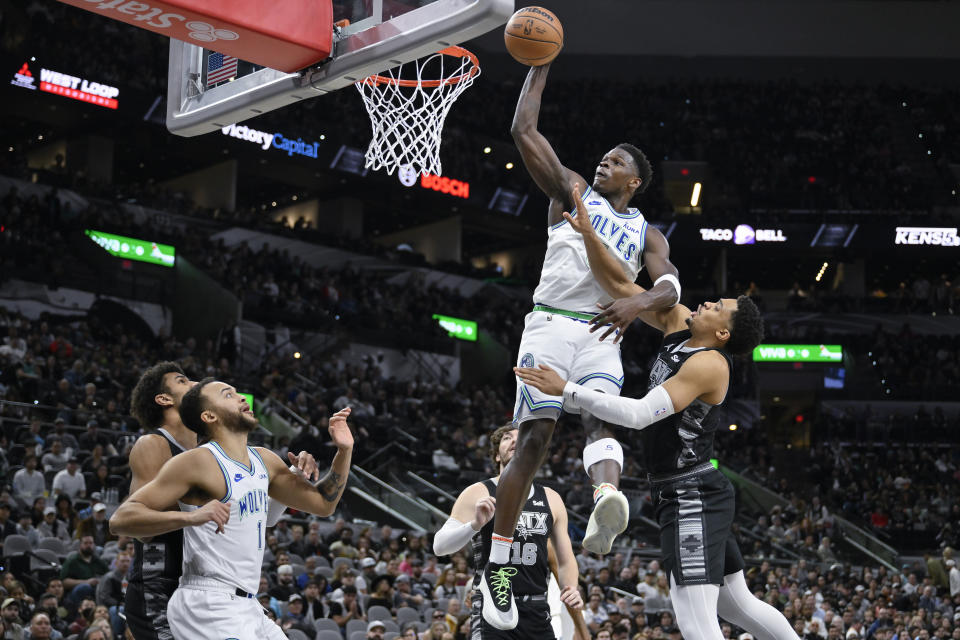 Minnesota Timberwolves' Anthony Edwards dunks against San Antonio Spurs' Keldon Johnson, right, during the first half of an NBA basketball game, Saturday, Jan. 27, 2024, in San Antonio. (AP Photo/Darren Abate)