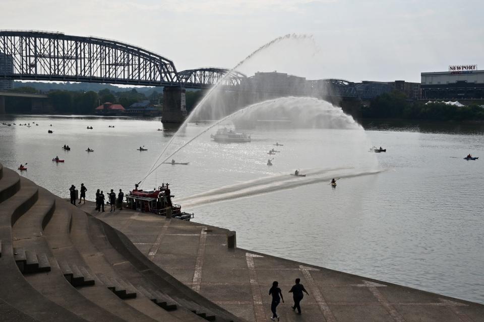 The Cincinnati Fire Department sprays Paddlefest participants in 2021 on the banks of the Ohio River.